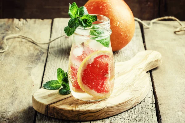 Grapefruit soda water with ice and mint leaves