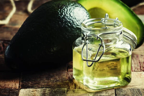 Cosmetic avocado oil in a glass jar — Stock Photo, Image