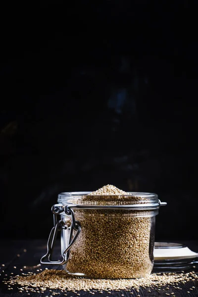 Quinoa i en burk på svart bakgrund — Stockfoto
