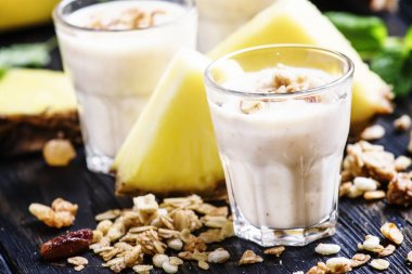 Muz, ananas ve granola ile süt smoothies