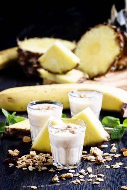 Muz, ananas ve granola ile süt smoothies