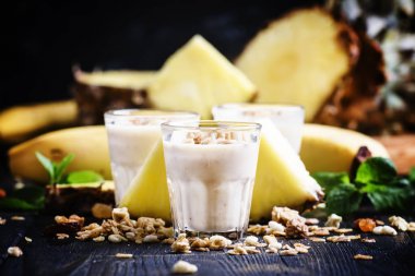 Muz, ananas ve granola ile süt smoothies