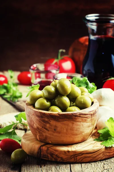 Groene olijven in een houten kom — Stockfoto