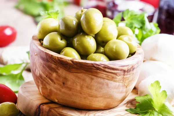 Gröna oliver i en träskål — Stockfoto
