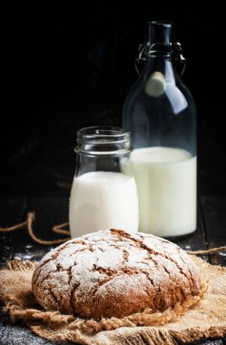 Taze ekmek ve inek şişelerde süt 