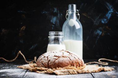 Taze ekmek ve inek şişelerde süt 