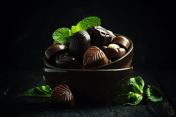 Шоколадные конфеты, ассорти, украшенные листьями мяты — стоковое фото