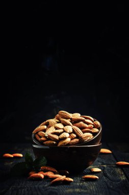 Bir kase, siyah arka planda badem