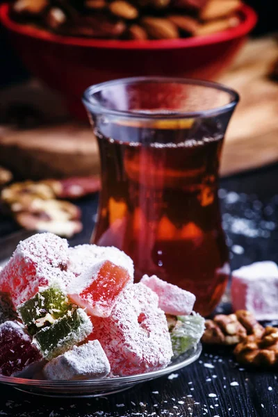 Czarna herbata i cukierki z orzechami — Zdjęcie stockowe