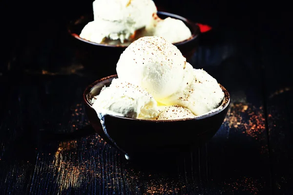 Vanilleeis mit gemahlenem Kakao in braunen Schalen — Stockfoto