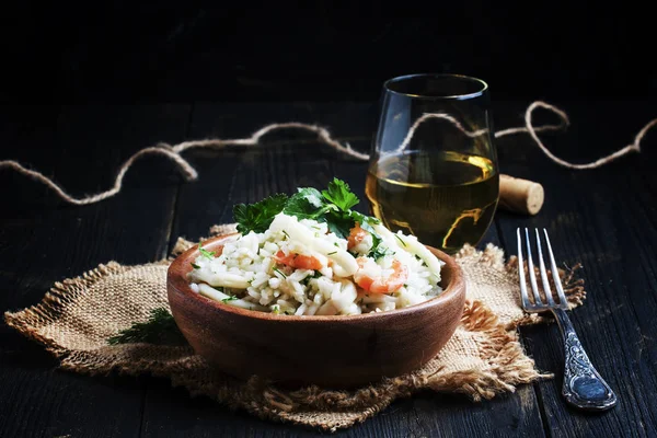 Risotto with shrimp and squid in a wooden bowl