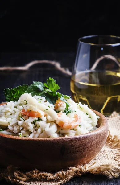 Risotto met garnalen en inktvis in een houten kom — Stockfoto