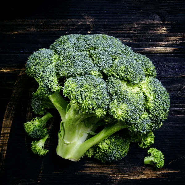 Verse broccoli op een donkere houten achtergrond — Stockfoto
