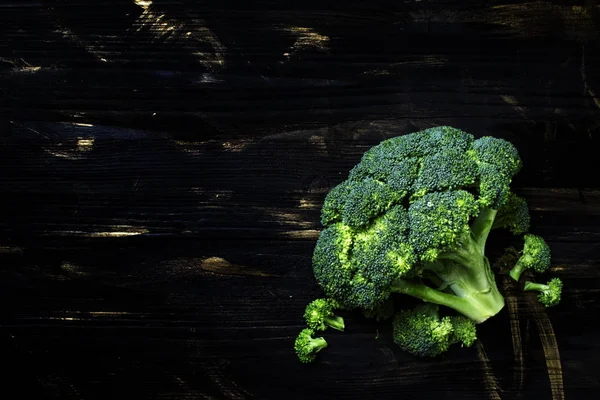 Verse broccoli op een donkere houten achtergrond — Stockfoto