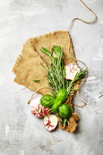 Fresh rosemary, green basil, pink garlic on canvas napkin — Stock Photo, Image
