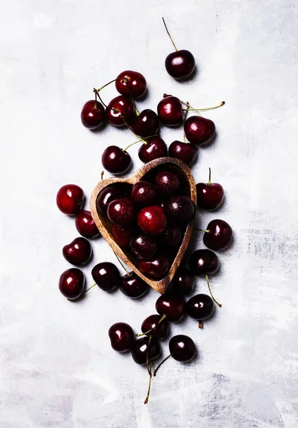 Cerezas dulces negras en tazón en forma de corazón —  Fotos de Stock