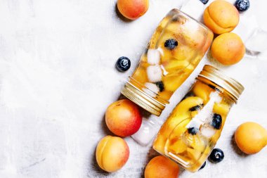 Kayısı ve cam şişelerde berry ile buzlu çay 