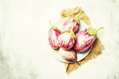 Plaka üzerinde taze çiğ çizgili patlıcan