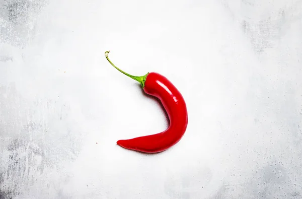 Syrové červené chili pepper na šedém pozadí — Stock fotografie