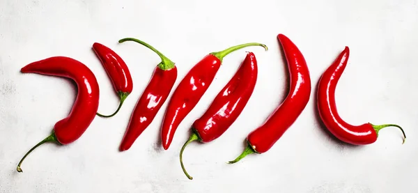 Čerstvé red hot chili papričky na šedém pozadí — Stock fotografie