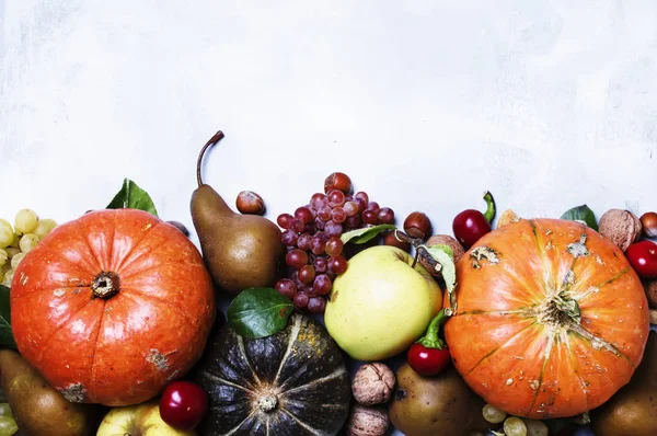 Herfst maaltijd achtergrond met pompoenen, groenten, fruit en noten — Stockfoto