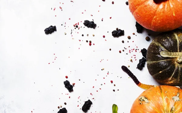 Хэллоуин фон, тыквы, черви и черные конфеты — стоковое фото