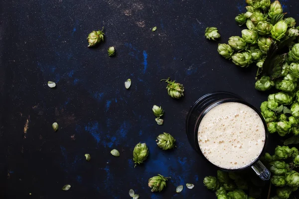 Grande bicchiere di birra schiumosa e coni di luppolo — Foto Stock