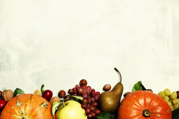 Voedsel achtergrond met pompoenen, groenten, fruit en noten — Stockfoto