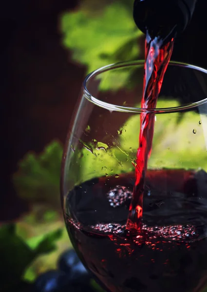 Rode wijn die in een glas giet — Stockfoto