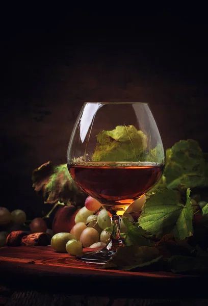 Cognac In glas, druiven en wijnstok — Stockfoto
