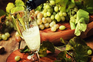 Champagne Pour In Glasses, Grapes With Vine, Vintage Wood Background, Selective Focus clipart