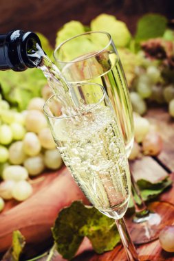 Şampanya Pour gözlük, üzüm asma, Vintage ahşap arka plan, seçici odak ile