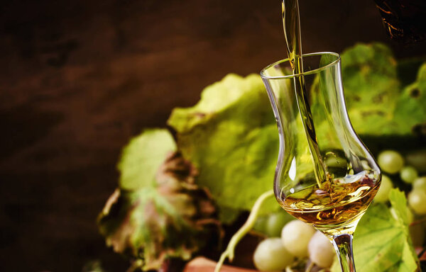Golden Grappa Being Poured Into Shot Glass, Rustic Still Life, Selective Focus