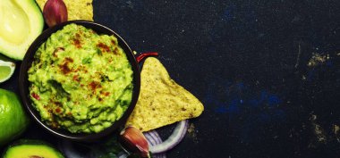Meksika yemeği, guacamole sosu ile avokado, soğan, sarımsak ve biber, siyah arka plan, üstten görünüm