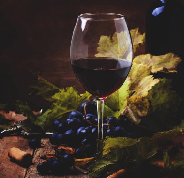 Kırmızı şarap üzümden cabernet sauvignon çeşitli, çilek ve asma, vintage ahşap arka plan, seçici odak rustik tarzı natürmort