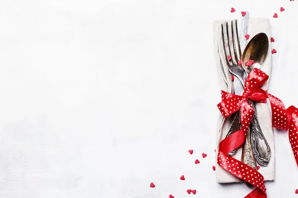 节日餐桌设置为情人节 餐具套装 红丝带和甜心 灰色背景 顶部视图 — 图库照片