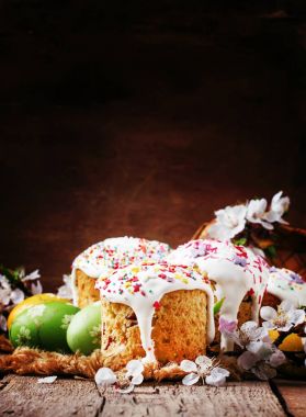 Paskalya kek ve yeşil ve sarı boyalı yumurta, beyaz kayısı çiçekler, rustik tarzı, Rus Ortodoks geleneği, vintage ahşap arka plan, seçici odak şenlikli kompozisyon