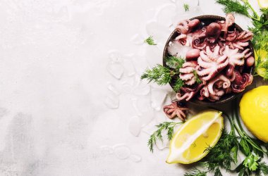 Yeşil otlar ve limon, gri arka planı, buzda küçük kırmızı ahtapot görünümü top