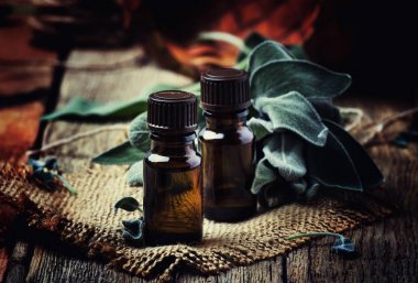 Antika ahşap blackground, rustik tarzı, seçici odak kahverengi şişede temel adaçayı yağı