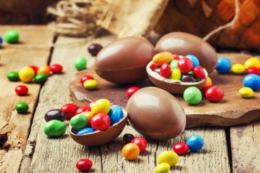 Çikolata yumurta ve renkli şeker, vintage ahşap arka plan, seçici odak ile Paskalya kompozisyon