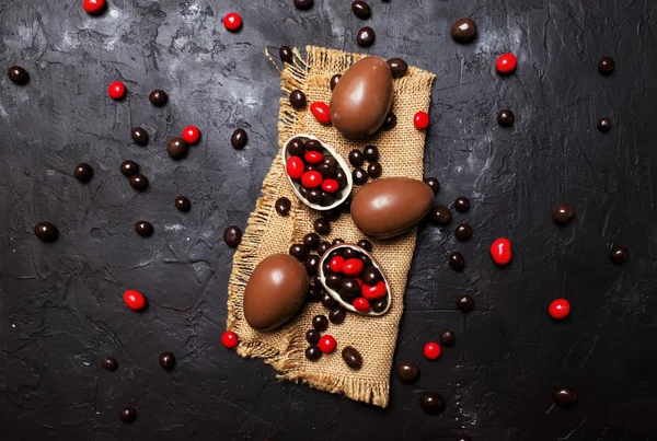 チョコレートの卵やお菓子 暗い背景の上面とイースター組成 — ストック写真