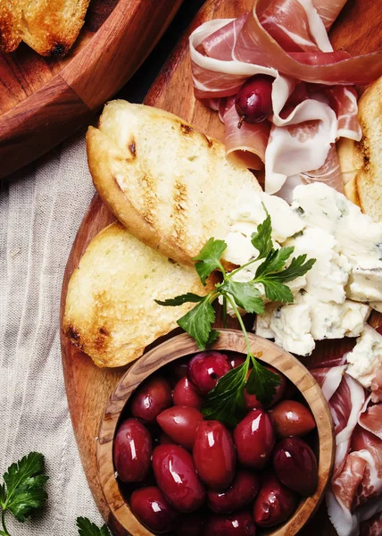 Snack Vagy Antipasti Crostinivel Prosciutto Kék Sajt Olajbogyó Fekete Háttér — Stock Fotó