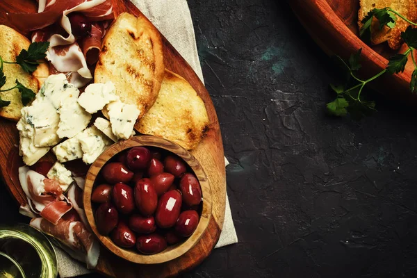 小吃或开胃小菜 Crostini 熏火腿 蓝色奶酪和橄榄 黑色背景 顶部视图 — 图库照片
