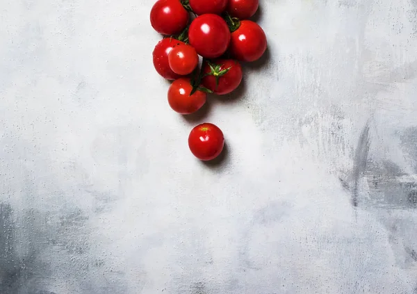 Cherry tomatoes on the vine, gray background, top view