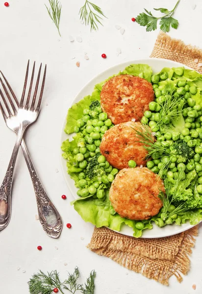 Fish cutlets from cod with garnish of green peas and broccoli, white background, top view — Stock Image Fish Cutlets Cod Garnish Green Peas Broccoli White Background Top Royalty Free Stock Images