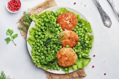 Balık pirzola üzerinden cod ile garnitür yeşil bezelye ve brokoli, beyaz arka plan, üstten görünüm