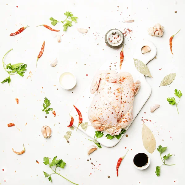 Raw whole chicken with spices and marinade, gray background, top view