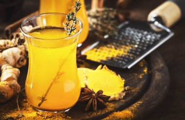 Tahta tepside cam bardakta bal bulunan sağlıklı vegan zerdeçal altın çayı. Şifalı baharatlı çay. 