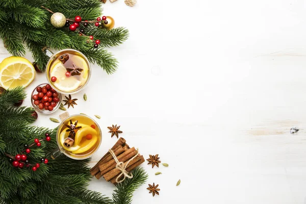 Winter hot tea with lemon, cranberries and spices for Christmas or New Year evening, white background, copy space, top view