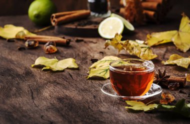 Cam bardak sonbahar sıcak siyah çay, eski ahşap masa arka plan, seçici odak